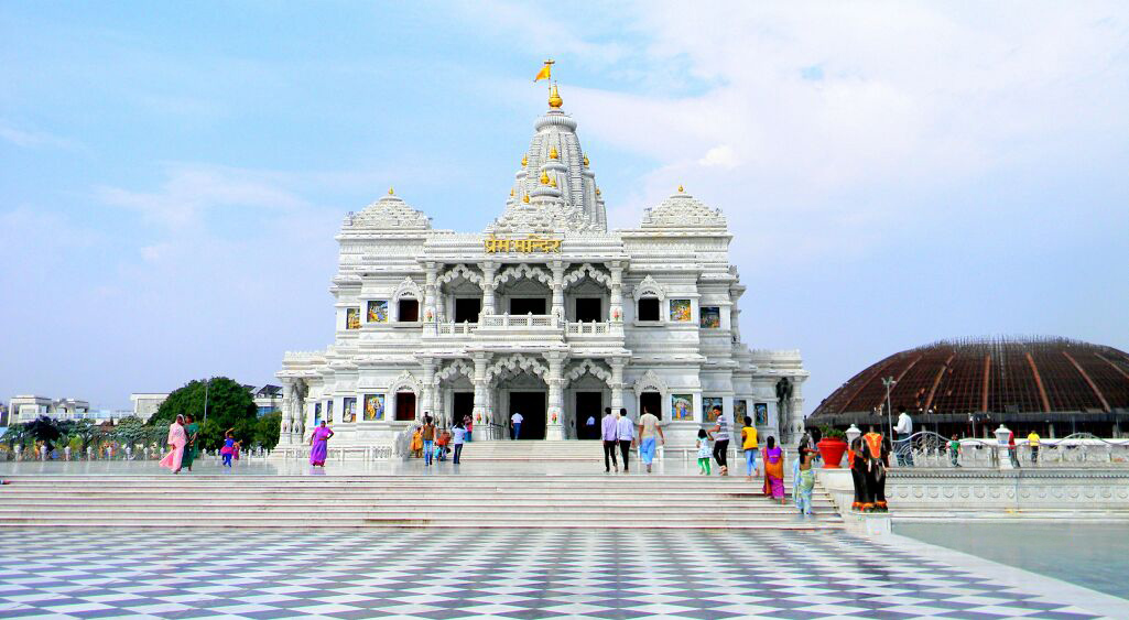 Front view of Prem Mandir, Vrindavan — white marble temple with devotees on the checkered courtyard